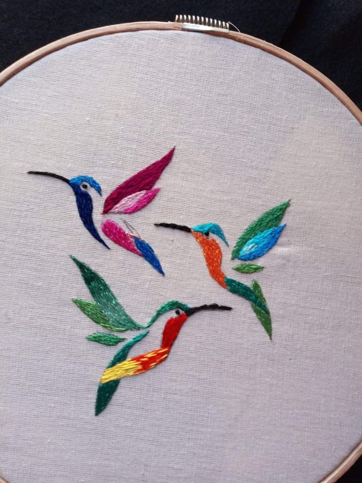 three colorful hummingbirds flying in the air on a white embroideryed wallhange