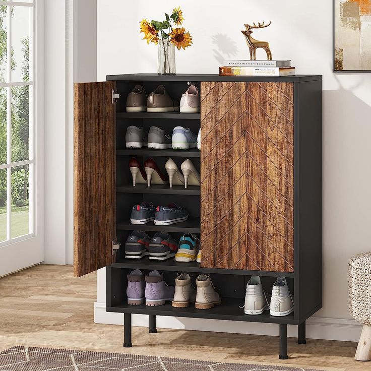 a shoe cabinet with several pairs of shoes on it in front of a window and rug