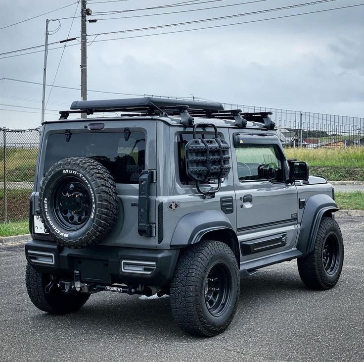 a grey jeep parked on top of a parking lot