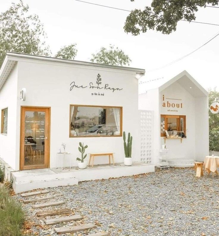 a small white building sitting on top of a gravel field