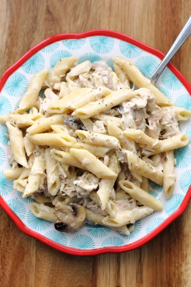 pasta with chicken and mushroom sauce in a bowl on a wooden table, ready to be eaten