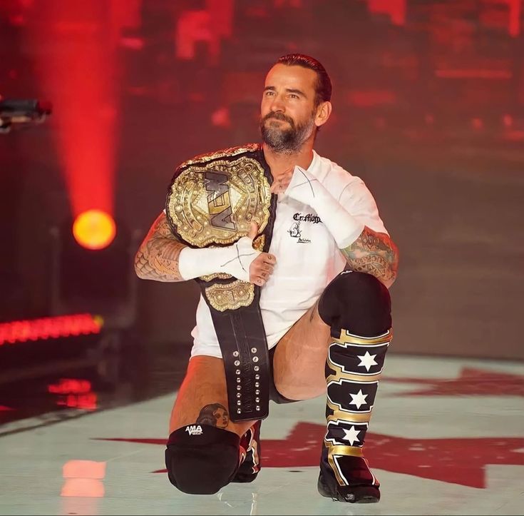 a man holding a wrestling belt in his right hand