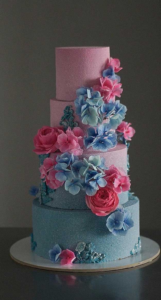 a three tiered cake with blue and pink flowers