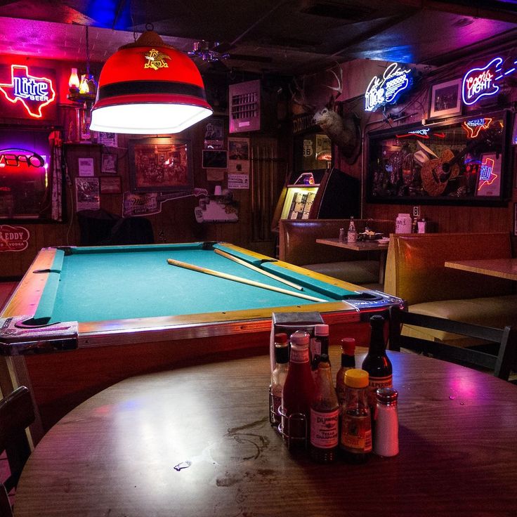 a pool table in a bar with neon lights