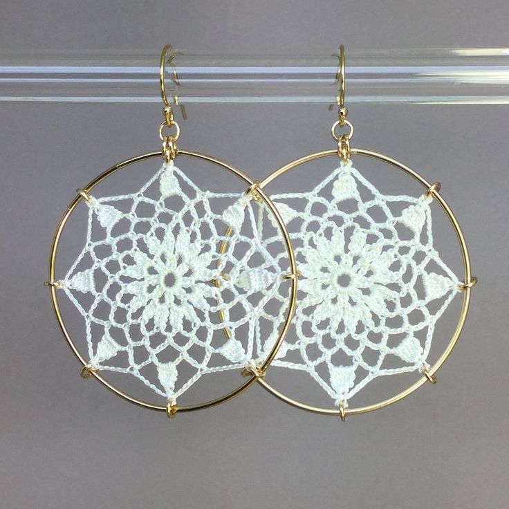 "Crochet doily earrings in white silk. Adapted from vintage motif \"No. 3\" from the 1940s. The diameter is approximately 1-5/8\", surrounded by 14K gold-filled hoops. They are lightweight and very comfortable. The jewelry has been treated with a water- and stain-repellent finish. Please be careful with your cosmetics and moisturizers, and you will have this lovely, lacy jewelry for years to come. Please remember, your screen may display colors differently from the actual item." Delicate Handmade White Hoop Earrings, Delicate White Hoop Earrings With Ear Wire, White Bohemian Filigree Earrings, White Round Filigree Earrings, Vintage White Filigree Earrings, Bohemian White Crochet Earrings, Bohemian White Pierced Hoop Earrings, White Bohemian Pierced Hoop Earrings, Crochet Earrings Pattern