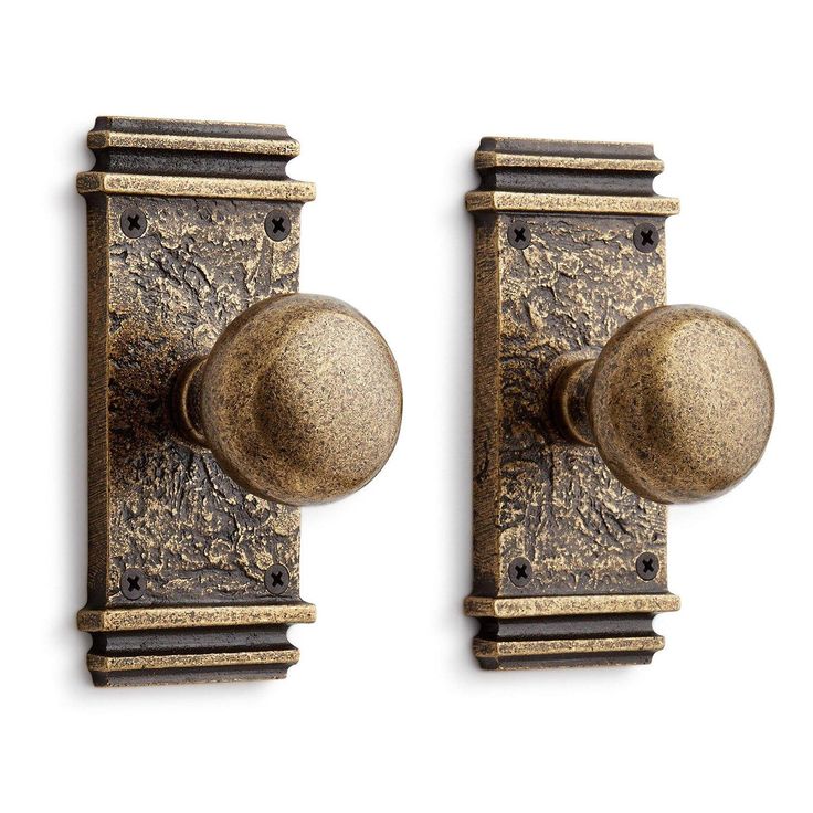 two antique brass door knobs on a white background