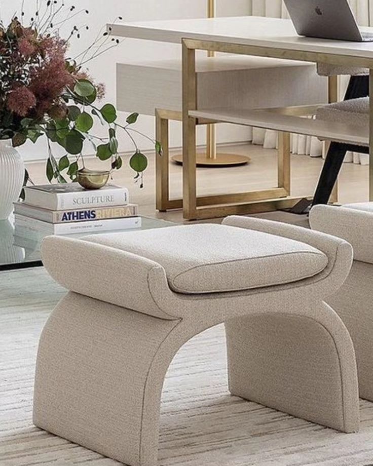 a living room with two chairs and a laptop on top of the table in front of it