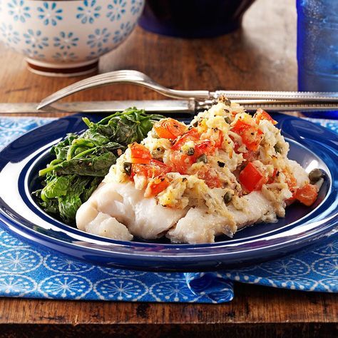 a blue plate topped with fish and vegetables