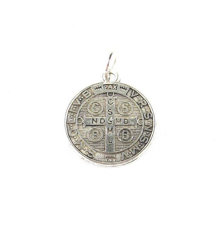 Size: About 3/4 inch diameter (2cm) Item number: whmsc143 This is a traditional St. Benedict amulet or medal with an image of St. Benedict on the front and a cross on the back. Both front and back are inscribed with symbols and various text in ecclesiastical Latin, one of which translates to 'Begone, Satan'. The St. Benedict medal is basically a Christian object believed to protect from curses, evil, and diseases and bring good health. Commemorative Coin Pendant, Engraved Coin-shaped Spiritual Jewelry And Charms, Engraved Spiritual Medallion Jewelry, Round Coin Pendant For Commemoration, Engraved Round Pendant For Commemoration, Spiritual Round Pendant Locket, Symbolic Engraved Crucifix Jewelry, Engraved Cross Pendant For Commemoration, St Benedict Medal