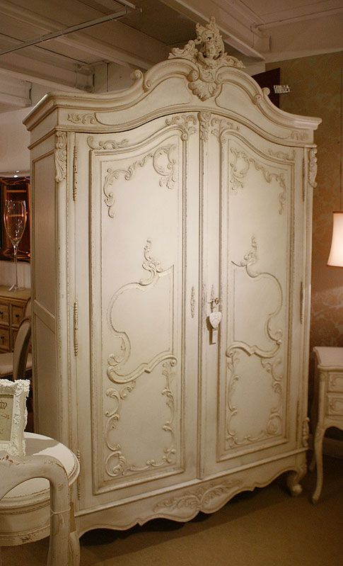 an antique white armoire in a store