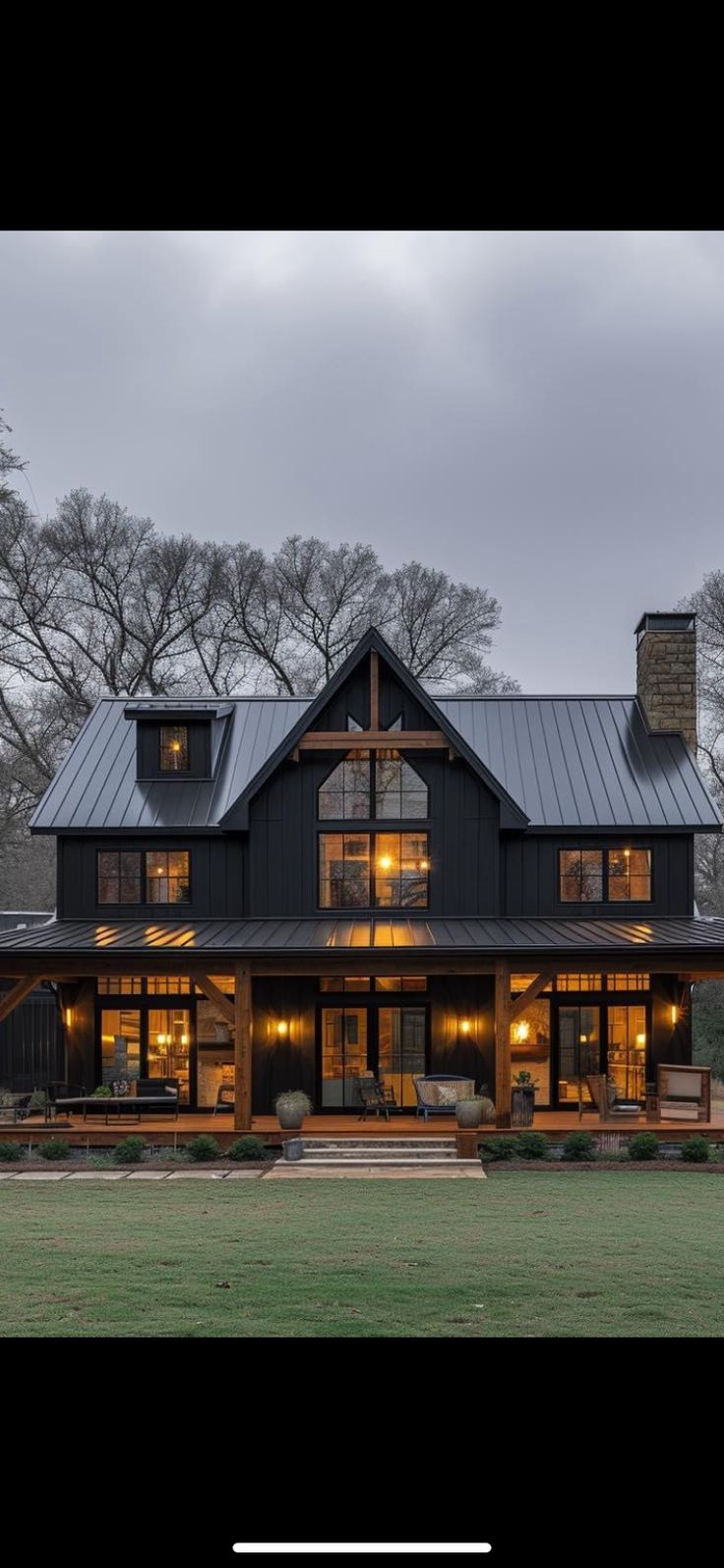 a large black house with lots of windows on it's roof and front porch