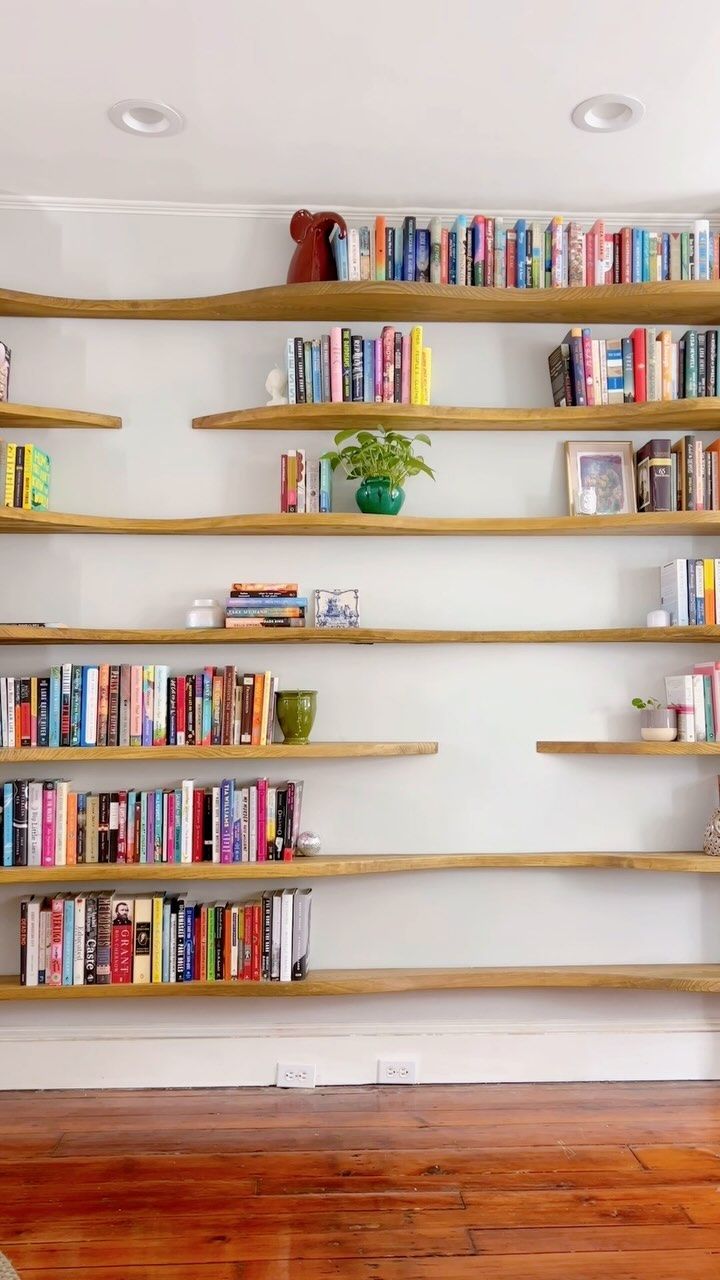 the bookshelves are lined up against the wall with many books on each shelf