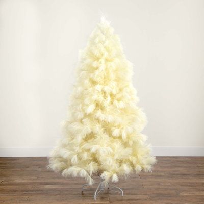 a small white christmas tree on a wooden floor