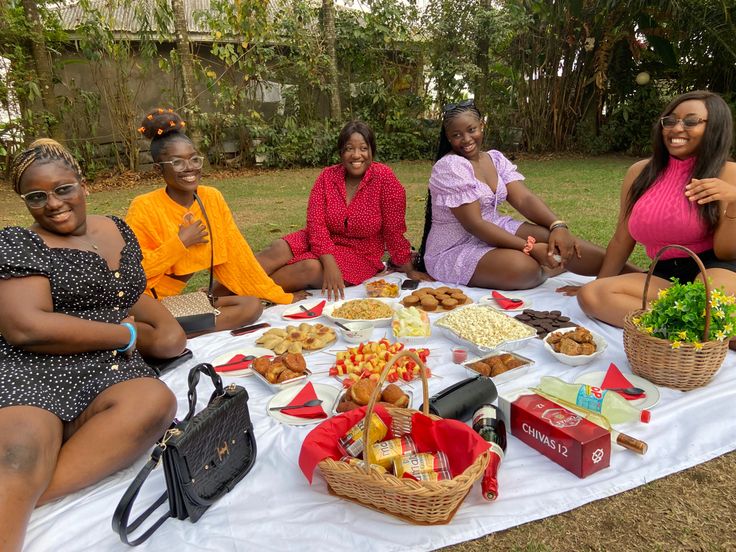 four women sitting around a table full of food