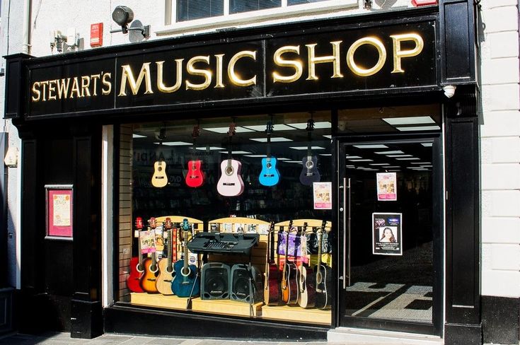 the storefront of stewart's music shop with guitars on display