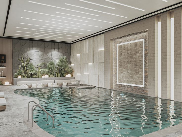 a large indoor swimming pool with lounge chairs and plants in the back drop off wall