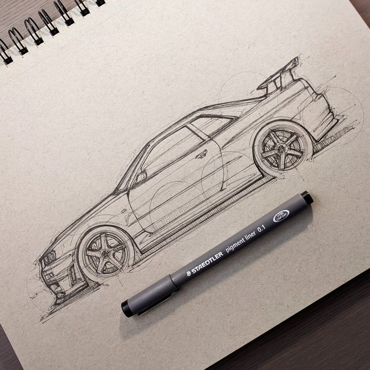 a pencil drawing of a car on top of a piece of paper with a pen next to it