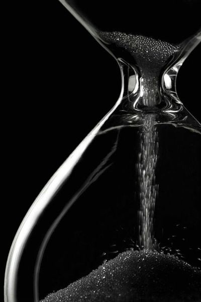 an hourglass with water pouring out of it and the words in arabic above it