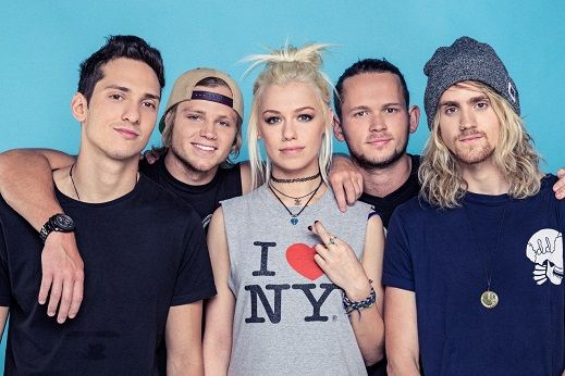 the group of young people are posing together for a photo in front of a blue background