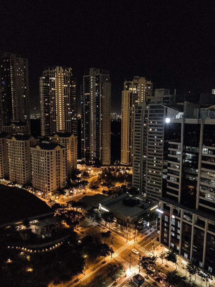 the city is lit up at night and it looks like there are no cars on the street