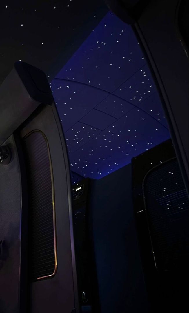 the ceiling is lit up with stars in the night sky as seen from inside an airplane