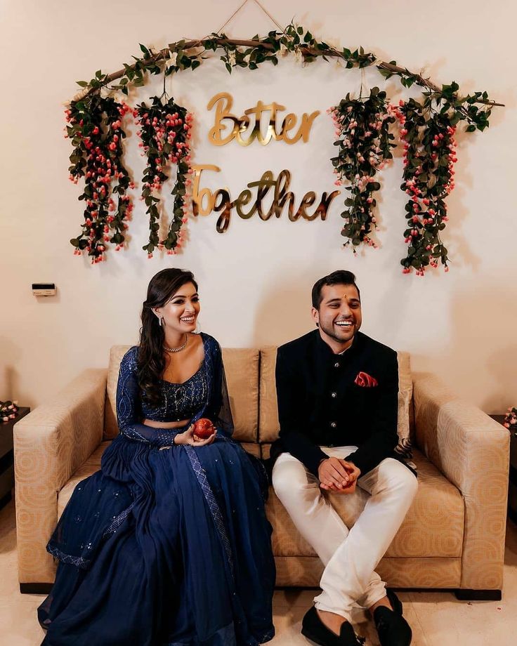 a man and woman sitting on a couch in front of a sign that says better together