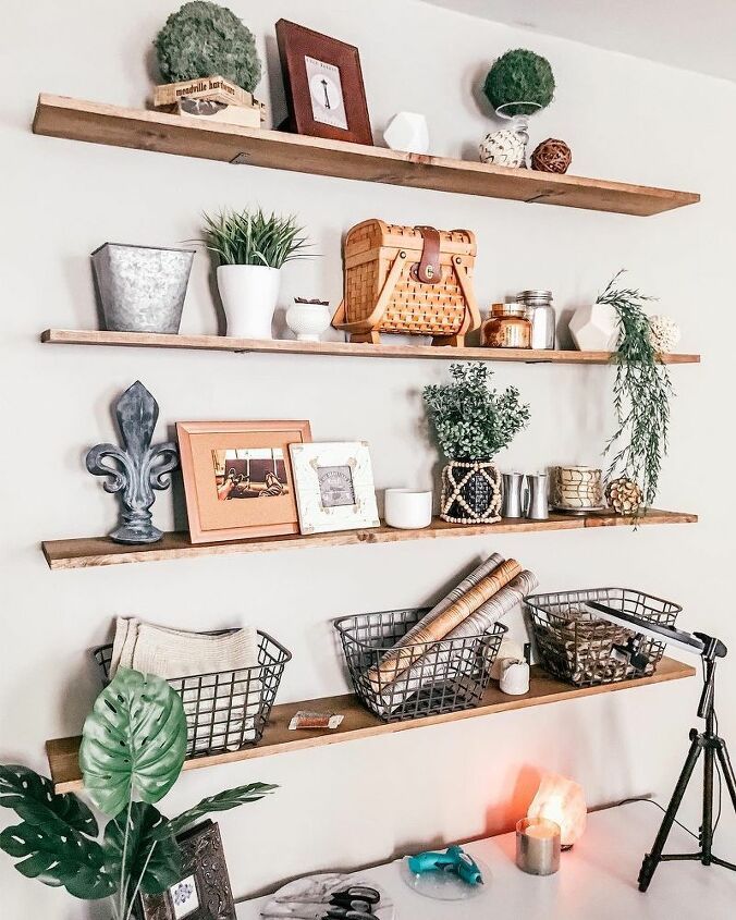 shelves with plants and pictures on them in a living room area, along with other decor items