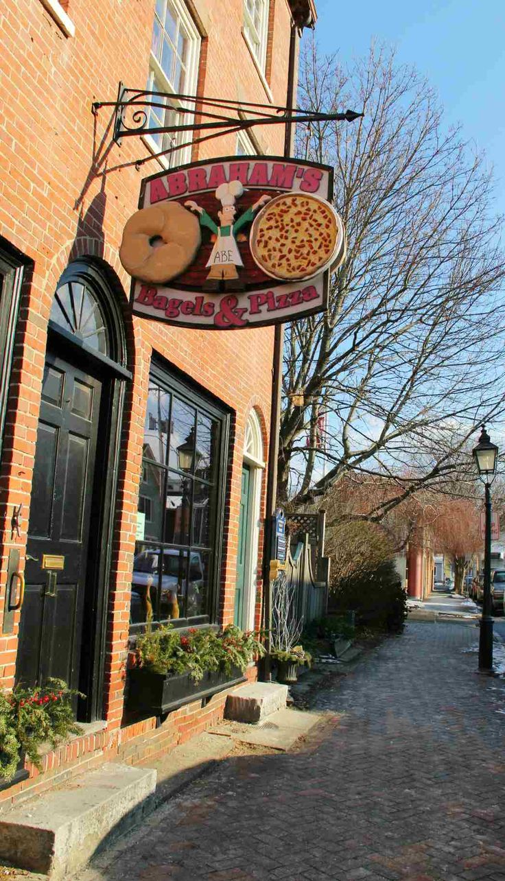 a brick building with a pizza sign hanging from the side of it's front