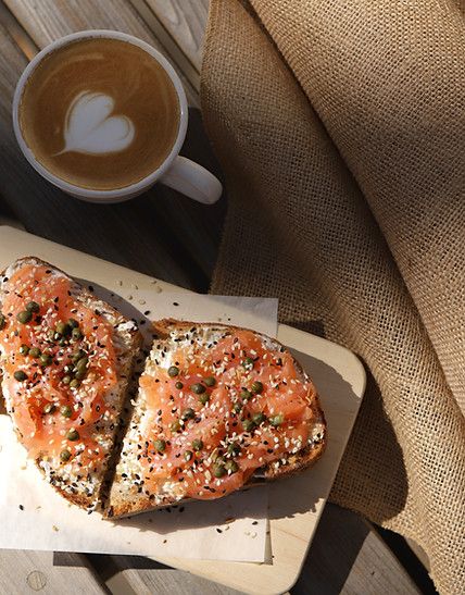 two pieces of bread on a tray next to a cup of coffee