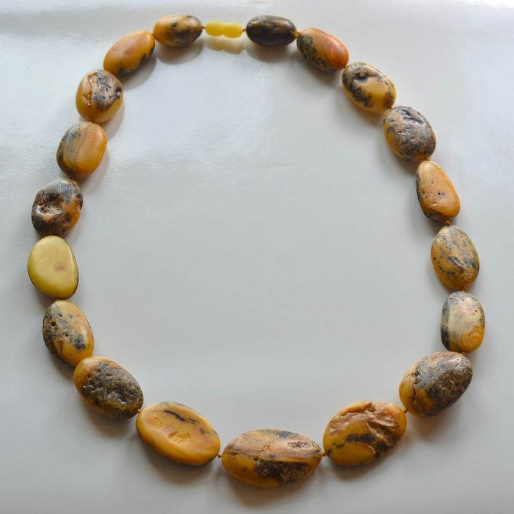 Baltic Amber Necklace Indulge in the timeless elegance of our Antique Colored Rustic Baltic Amber Necklace. This exquisite piece features larger-than-average beads full of Inclusions, each radiating a unique, old-world charm that is both captivating and sophisticated. 23 inches in length, largest focal bead measures 37X22X12mm. Made in Lithuania. You will receive one Necklace, the exact Necklace in the photos. Arrives to your home with the "All About Amber" Brochure which includes care instructions. Elegant Amber Jewelry With Large Beads, Antique Amber Necklaces With Polished Beads, Antique Amber Necklace With Polished Beads, Classic Handmade Amber Necklaces, Handmade Amber Necklace Classic Style, Amber Necklaces With Polished Oval Beads, Classic Necklace With Large Beads For Gift, Amber Polished Oval Bead Jewelry, Amber Polished Oval Beads Jewelry