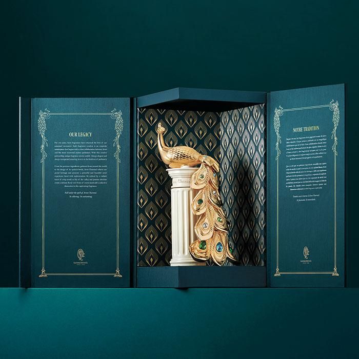 an open box with a peacock figurine in it's display case on a shelf