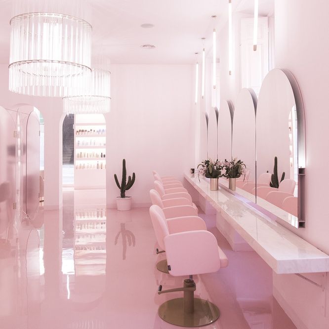 a room with pink chairs and mirrors in it