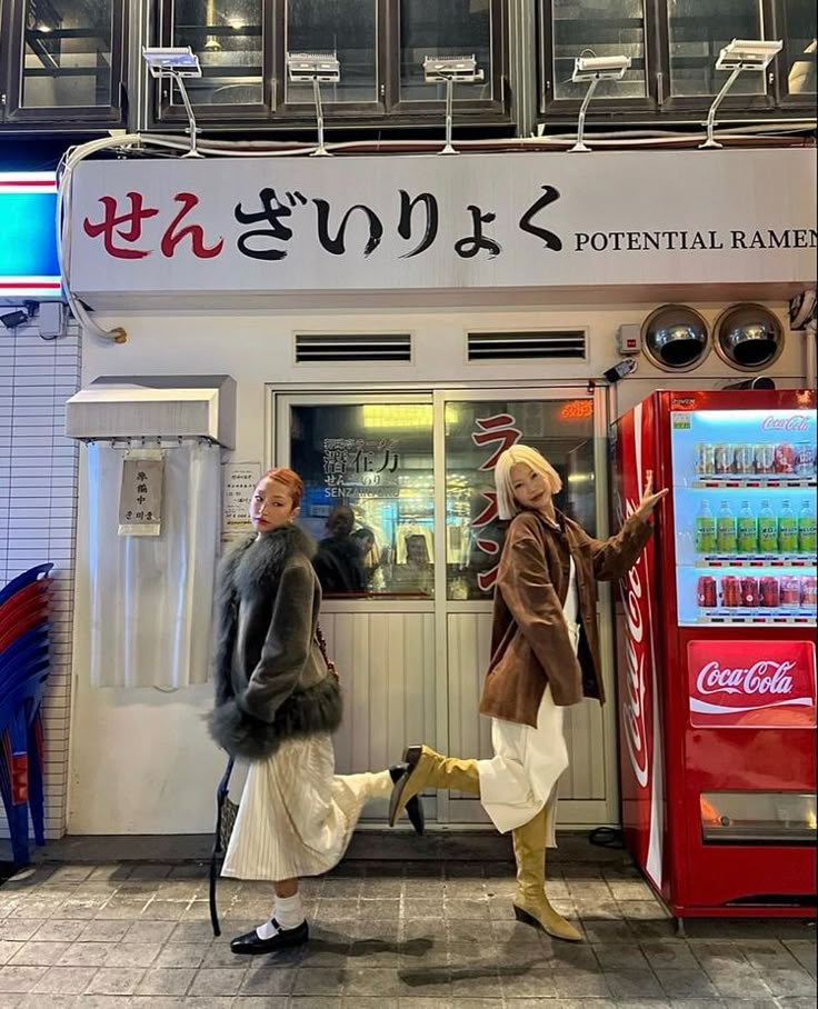 two mannequins dressed in costumes are standing next to a vending machine