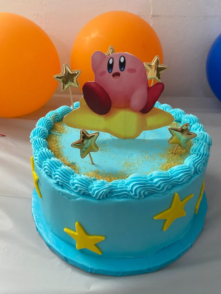 a blue cake with gold stars on it and a pink pig sitting in the middle