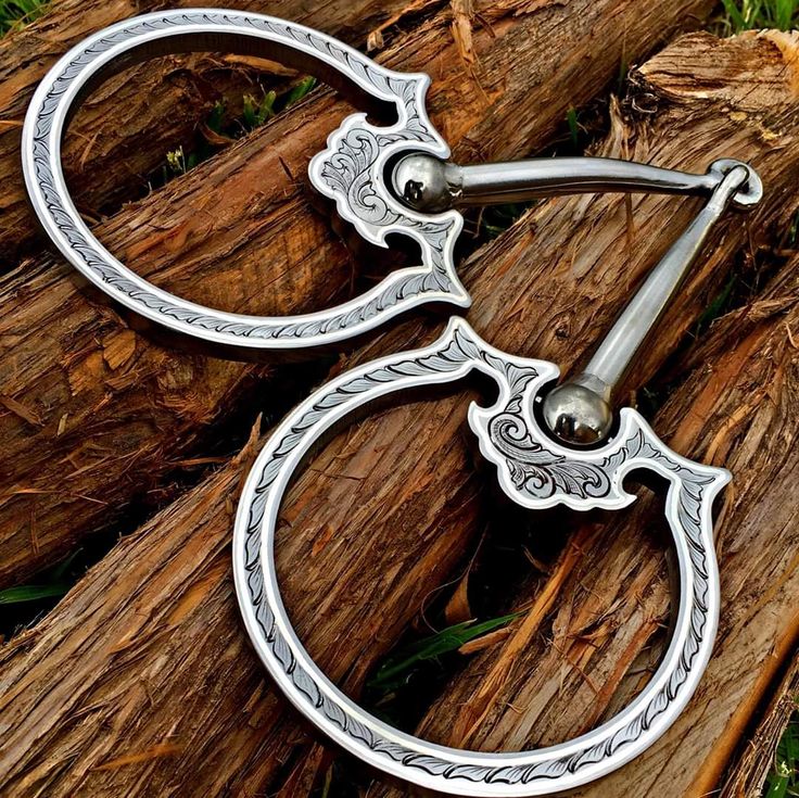 a pair of metal scissors sitting on top of a piece of wood