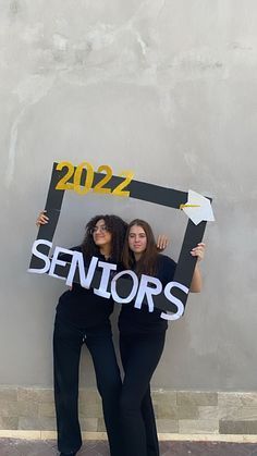 two women holding up a sign that says seniors