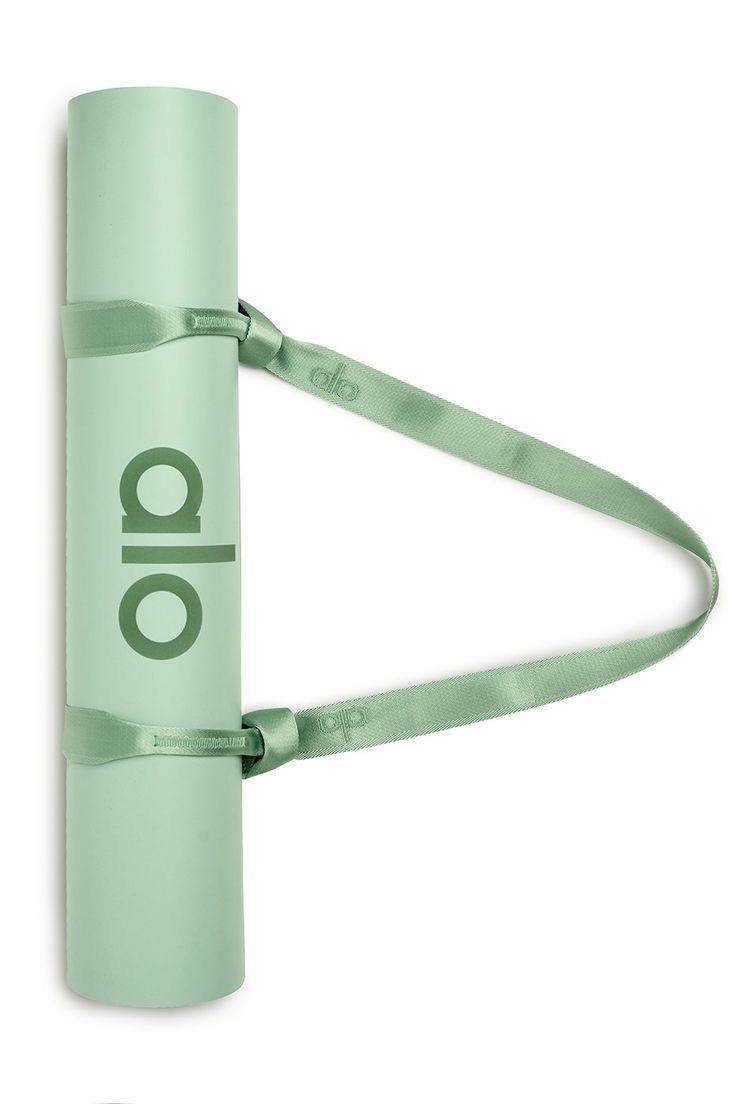 a green yoga mat with the word oio on it and a strap around it