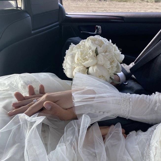 a bride and groom sitting in the back seat of a car with their hands on each other