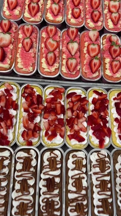 many trays of strawberries and chocolate covered desserts