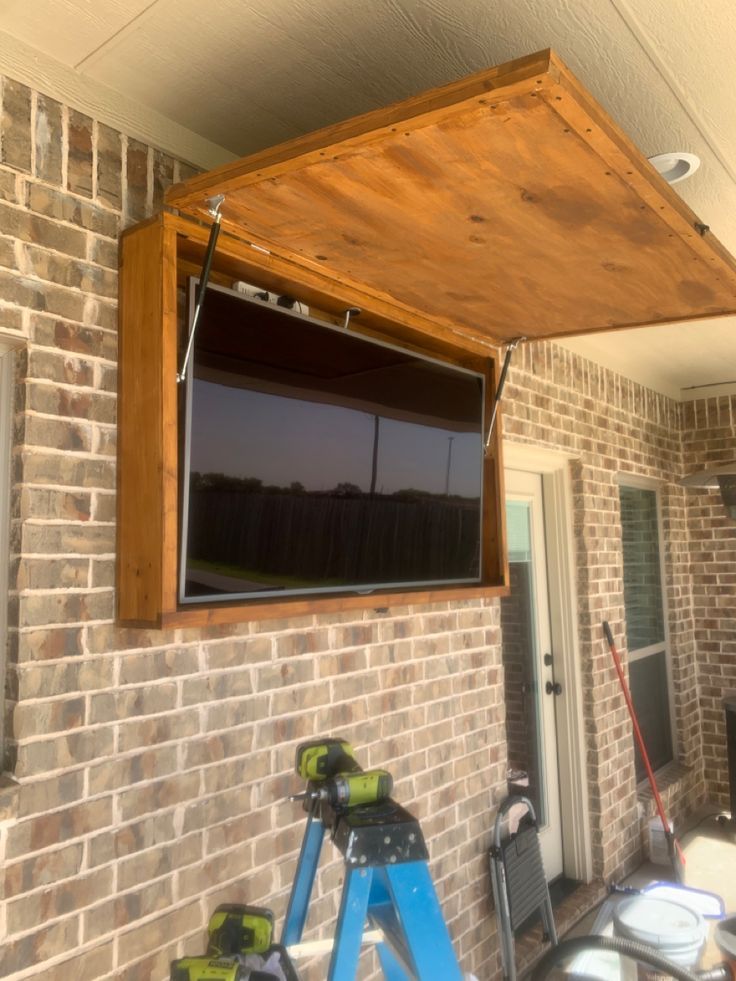 a flat screen tv mounted to the side of a brick building