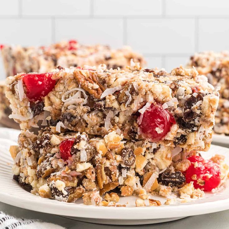 two pieces of granola bars stacked on top of each other with cranberries and coconut