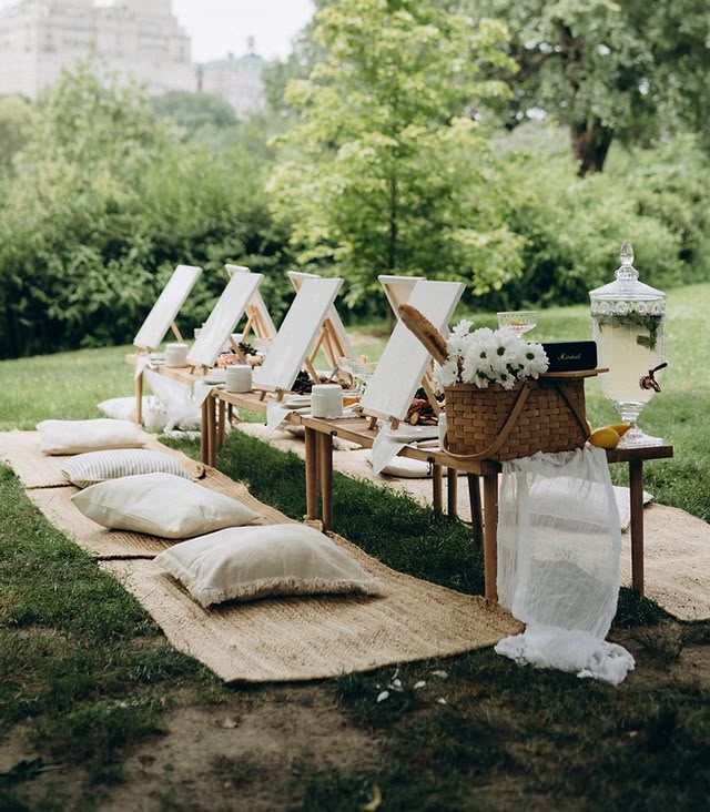 an outdoor ceremony setup with white linens and pillows