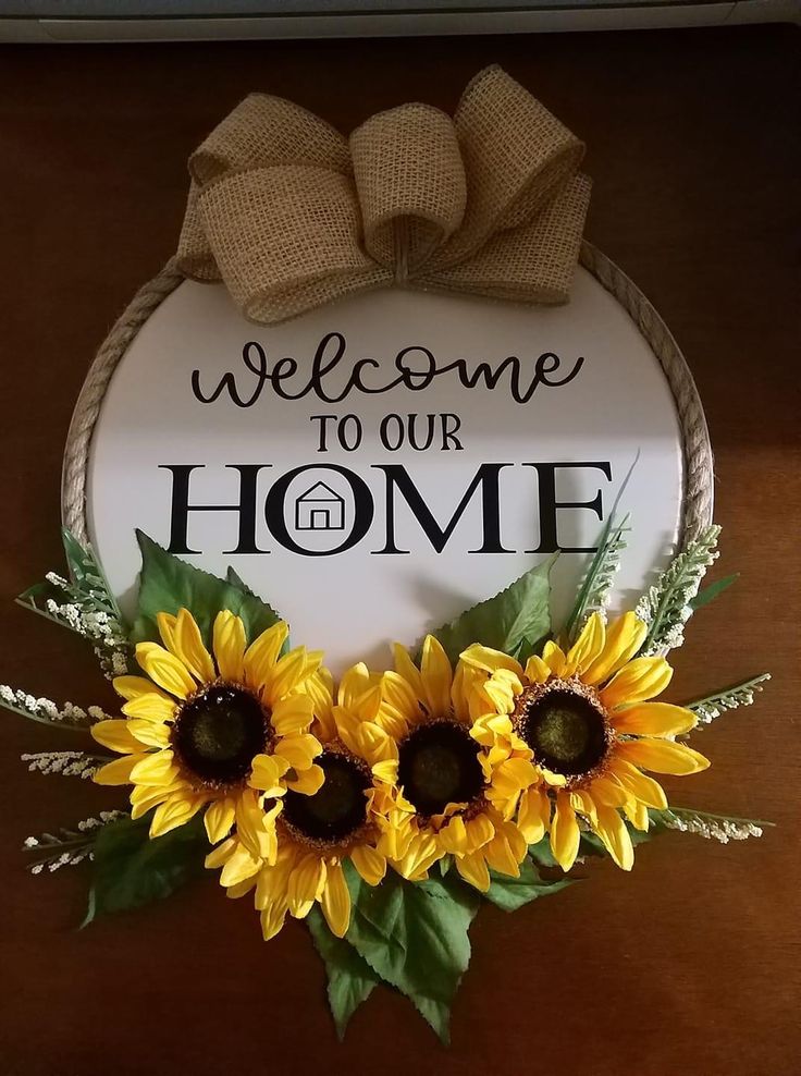 a welcome sign with three sunflowers in front of it that says welcome to our home