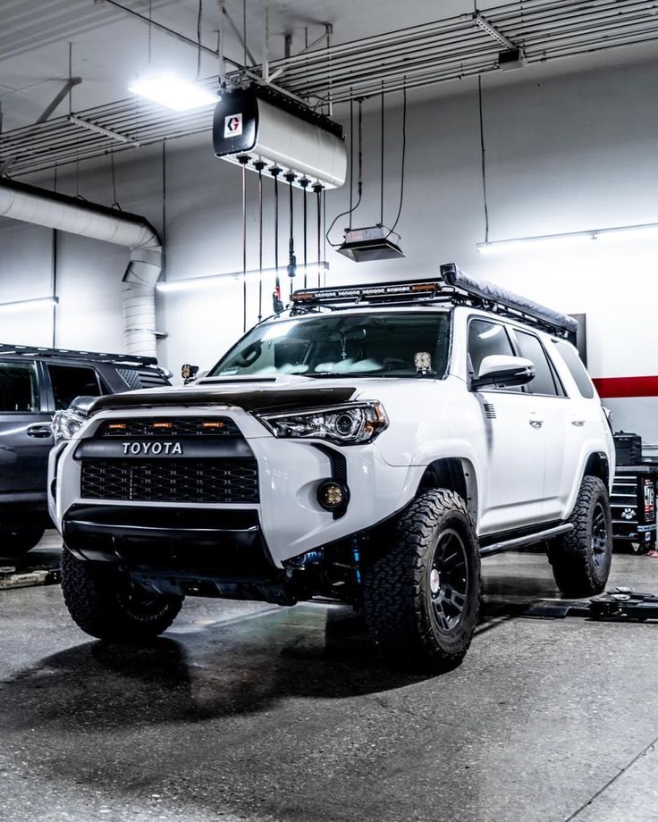 a white truck parked in a garage next to other vehicles