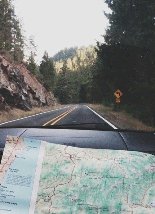 a car driving down a road with a map on the dashboard and an arrow pointing up