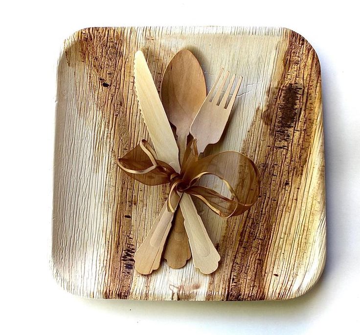 wooden utensils and spoons are arranged in a square shape on a white surface