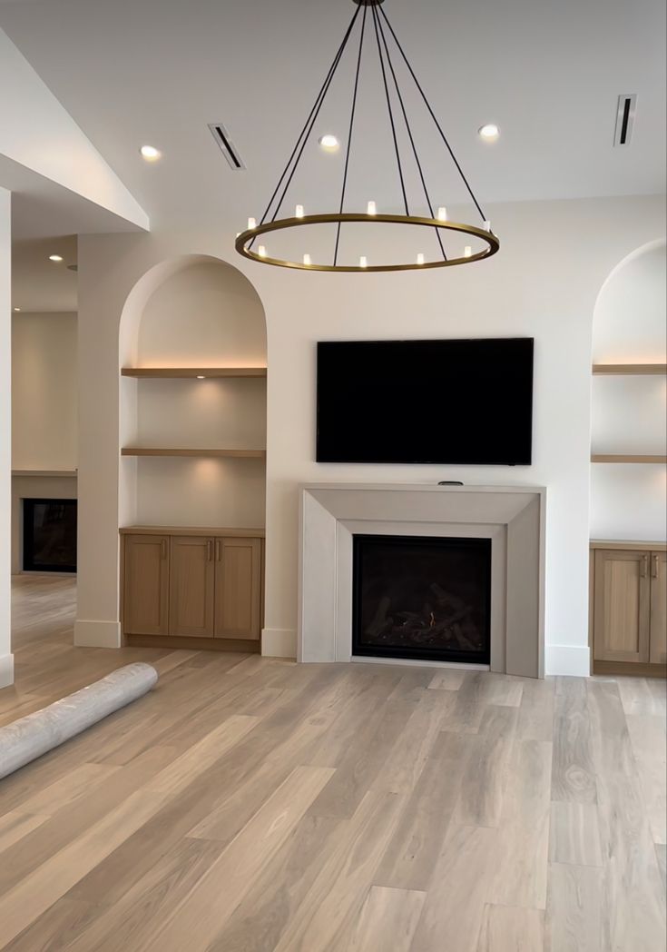 an empty living room with a fireplace and tv