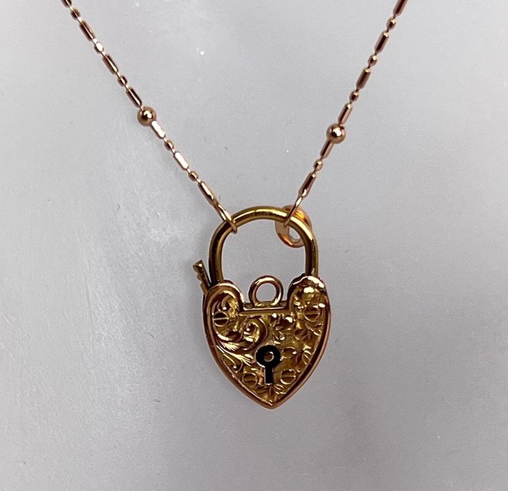 Beautiful example of hand engraved Heart Shape Padlock Charm. This item is 20 millimeters tall and 12 millimeters wide. It is hallmarked and made in 9 karat rose gold and it weighs 1.2 grams The 10 karat rose gold chain is a newer addition and it weighs 1.4 grams. Total weight is 2.6 grams Rose Gold Necklace With Spring Ring Clasp For Anniversary, Luxury Engraved Rose Gold Jewelry, Anniversary Rose Gold Necklace With Spring Ring Clasp, Victorian 14k Rose Gold Necklace, 14k Rose Gold Formal Necklace, 14k Rose Gold Necklace For Formal Occasions, Formal 14k Rose Gold Necklace In Gold Color, Rose Gold Heirloom Necklace For Formal Occasions, Antique Engraved Rose Gold Necklace