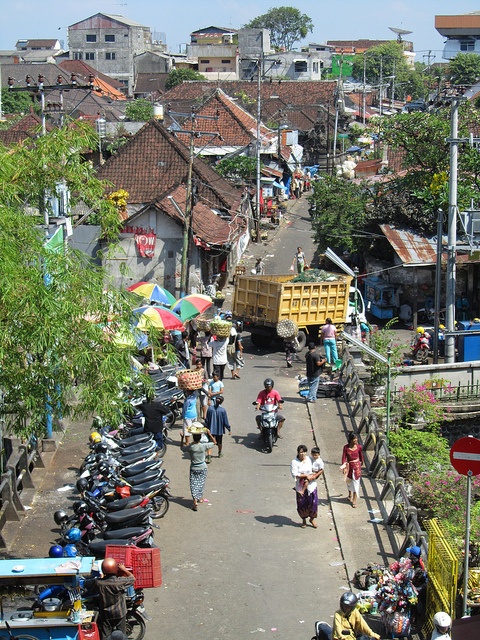 people are walking down the street with many scooters and mopeds on it