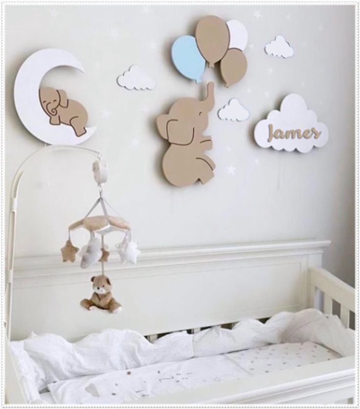 a baby crib with teddy bears hanging on the wall